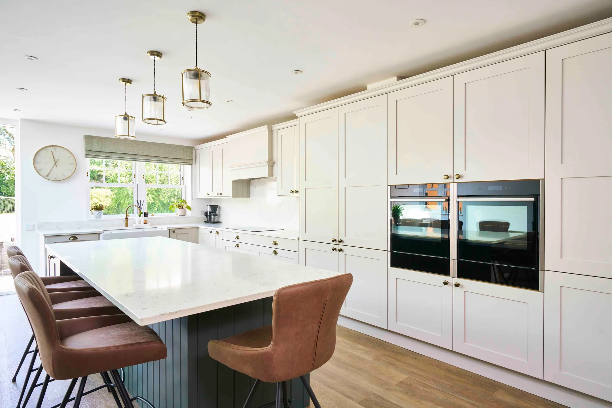 Luxury bespoke Shaker kitchen with marble island and brass pendant lighting, designed for a home in Chigwell